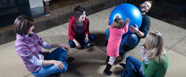 Family of five playing and sitting together on the floor | Family Therapy