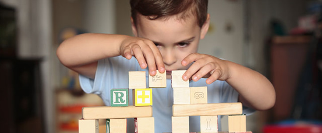 Child playing with wooden blocks | Play Therapy